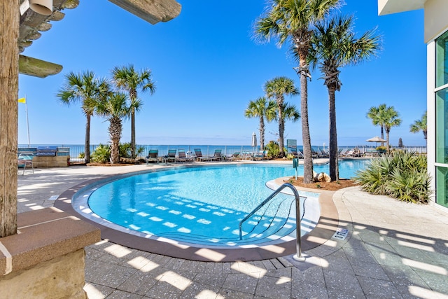 community pool featuring a water view and a patio area