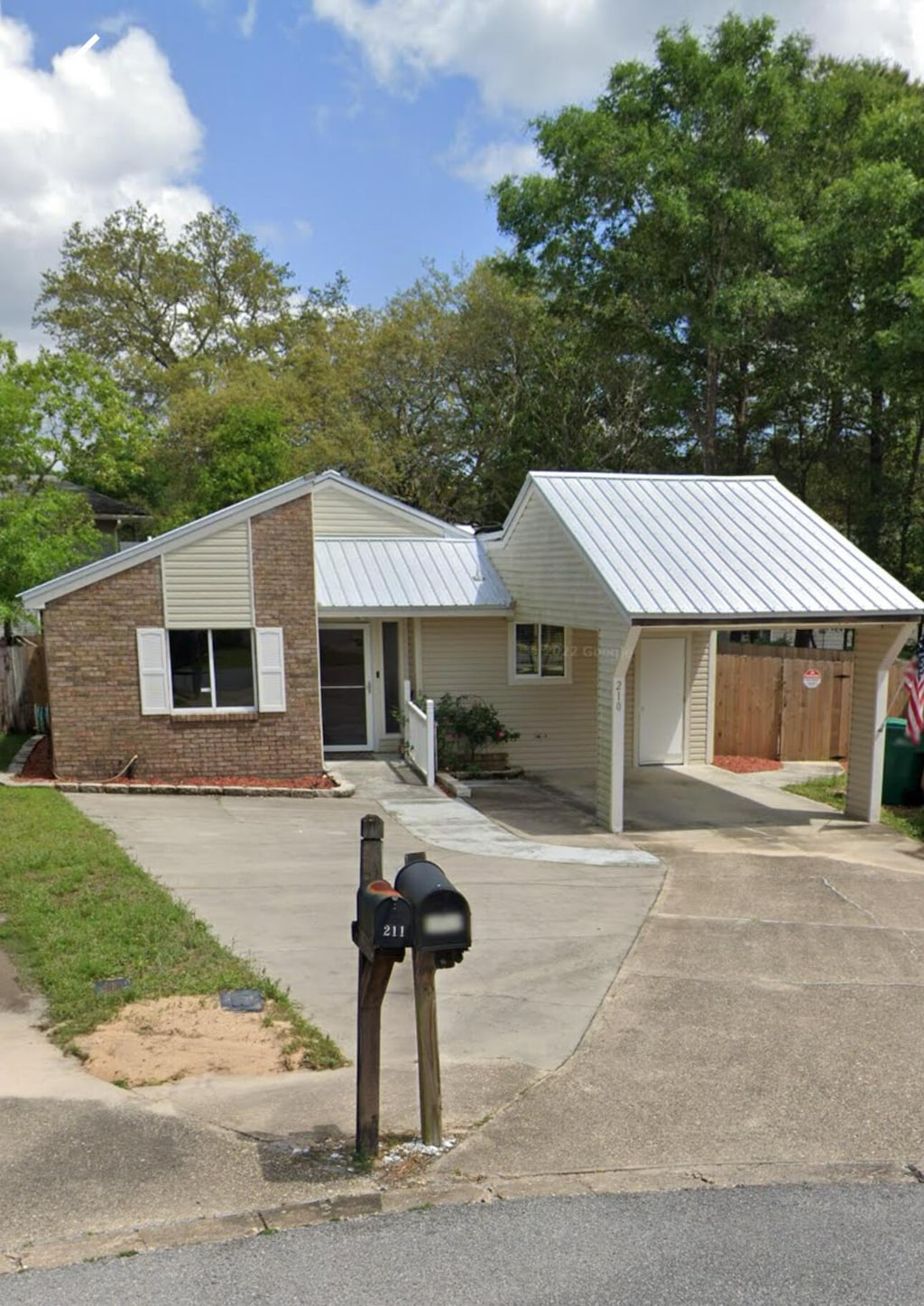 view of front of home featuring a carport, driveway, and metal roof