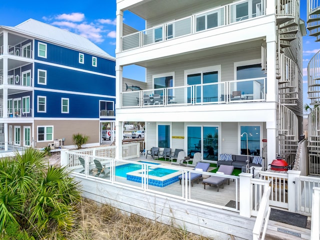 back of house featuring an outdoor living space, a pool with connected hot tub, and a patio