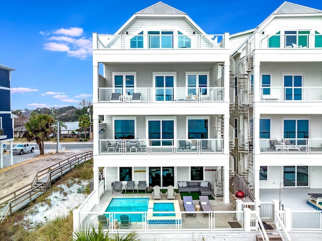 rear view of property featuring an outdoor living space, stairway, a patio, and fence