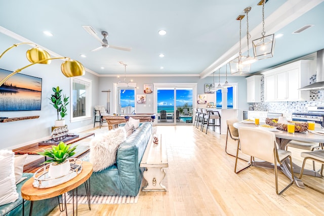 living room featuring visible vents, recessed lighting, ceiling fan, ornamental molding, and light wood-style floors