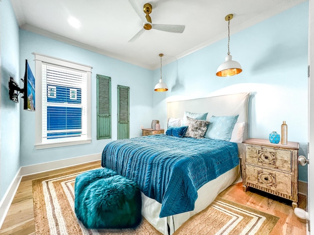 bedroom with baseboards, wood finished floors, and ornamental molding