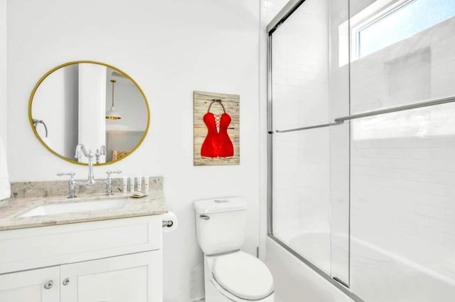 bathroom with vanity, toilet, and combined bath / shower with glass door