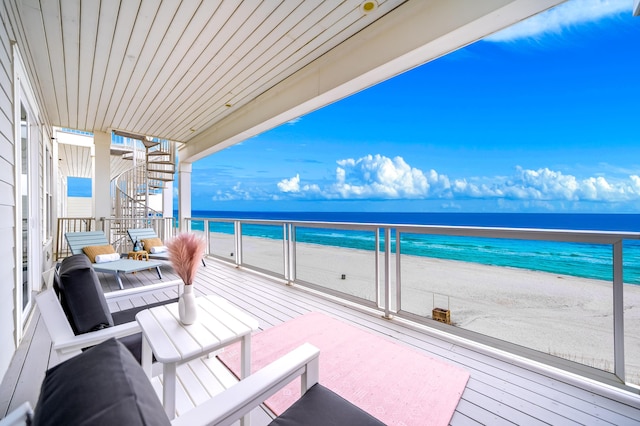 balcony featuring a water view and a beach view