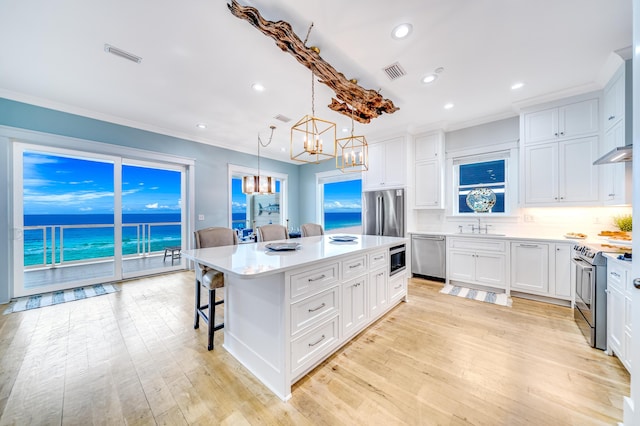 kitchen featuring a breakfast bar area, a notable chandelier, visible vents, and appliances with stainless steel finishes