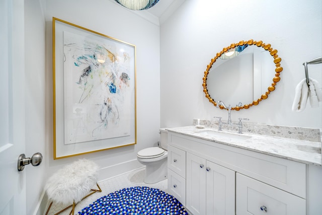 bathroom with toilet, vanity, and tile patterned flooring