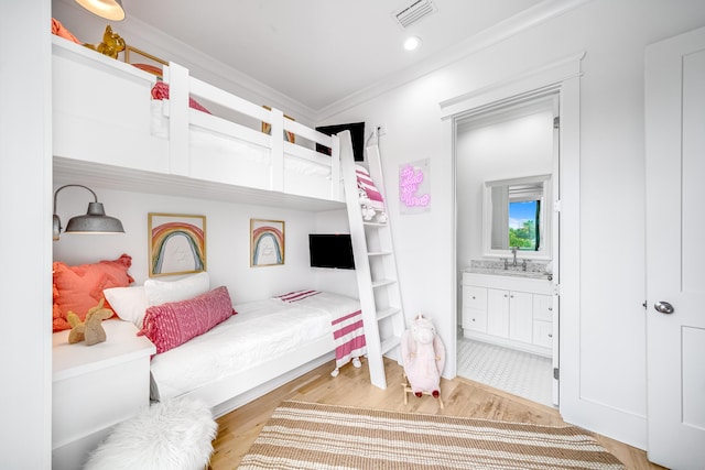 bedroom with light wood-type flooring, visible vents, ornamental molding, recessed lighting, and connected bathroom