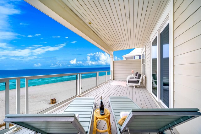 balcony featuring a water view and a view of the beach