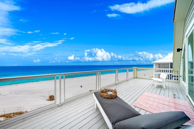 balcony featuring a water view and a beach view