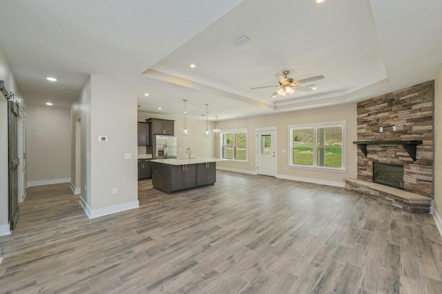 1517 Kais St, Baker, FL 32531 - unfurnished living room with light wood finished floors, a raised ceiling, visible vents, a ceiling fan, and a fireplace