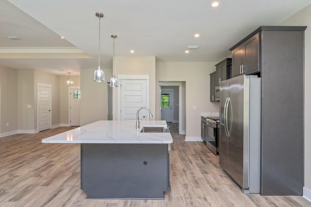 1517 Kais St, Baker, FL 32531 - kitchen with light wood finished floors, a kitchen island with sink, a sink, baseboards, and appliances with stainless steel finishes