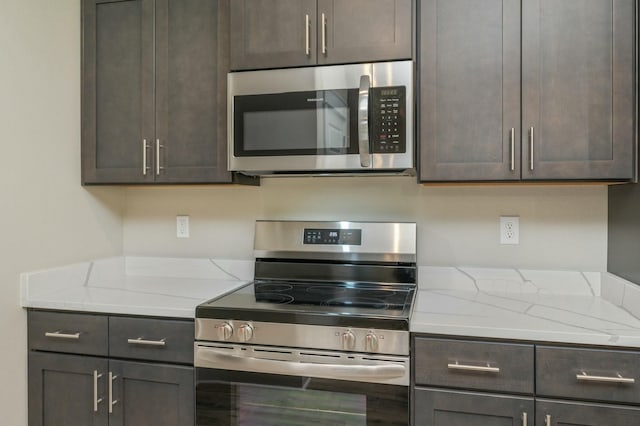 1517 Kais St, Baker, FL 32531 - kitchen featuring light stone counters, dark brown cabinetry, and appliances with stainless steel finishes