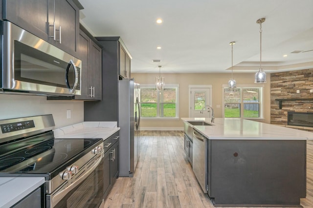 1517 Kais St, Baker, FL 32531 - kitchen with a sink, light wood-style floors, pendant lighting, stainless steel appliances, and a center island with sink