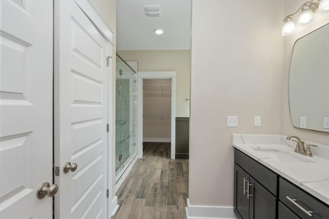 1517 Kais St, Baker, FL 32531 - full bathroom with a stall shower, baseboards, a spacious closet, wood finished floors, and vanity