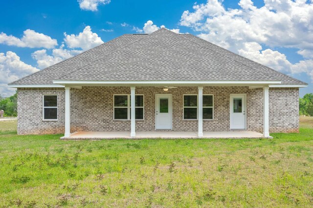 1517 Kais St, Baker, FL 32531 - rear view of house featuring a lawn, brick siding, a patio, and a shingled roof