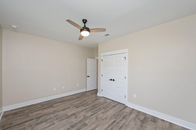 5390 Aidan St, Baker, FL 32531 - unfurnished bedroom with wood finished floors, baseboards, ceiling fan, and a closet