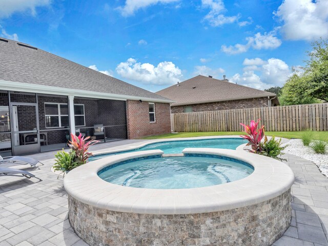 view of swimming pool featuring a patio area, an in ground hot tub, and a fenced backyard