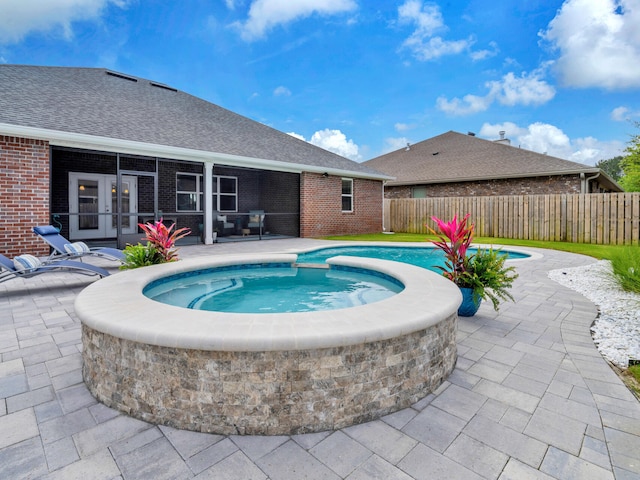view of swimming pool featuring a sunroom, a fenced backyard, a patio area, an in ground hot tub, and a fenced in pool