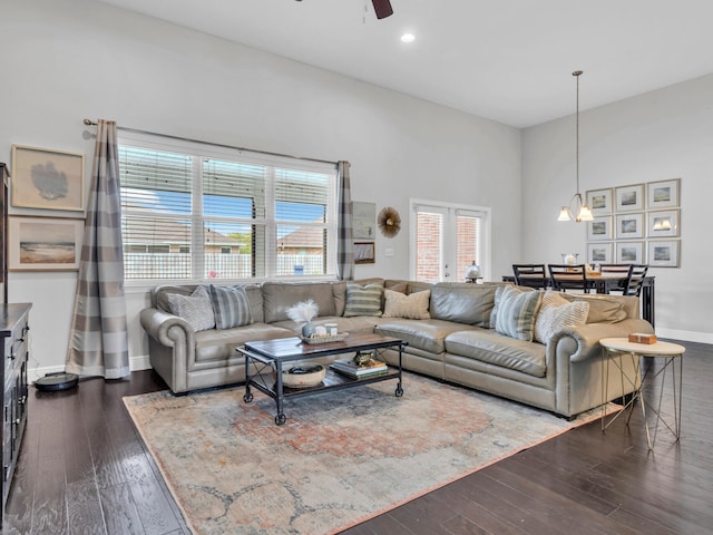 living area with baseboards, dark wood finished floors, recessed lighting, a towering ceiling, and ceiling fan with notable chandelier