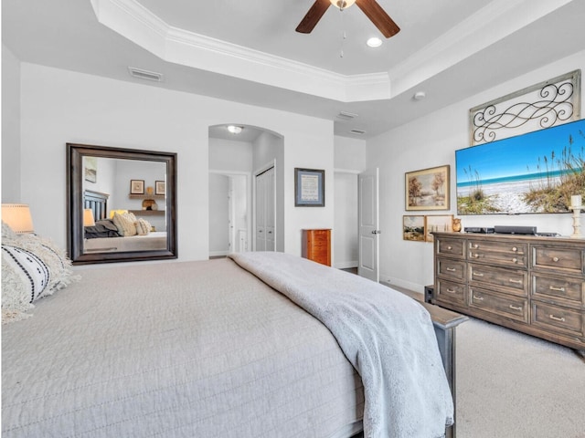 bedroom featuring ornamental molding, visible vents, a raised ceiling, and arched walkways