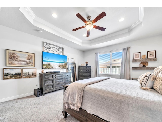 bedroom with a raised ceiling, crown molding, baseboards, and carpet