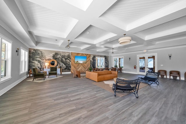 living room with baseboards, beamed ceiling, coffered ceiling, and wood finished floors