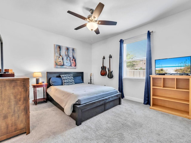 carpeted bedroom featuring baseboards and a ceiling fan
