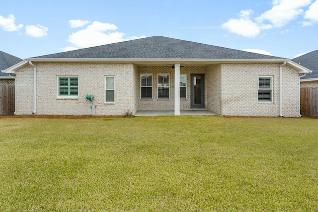 back of house with a patio area, a lawn, roof with shingles, and fence