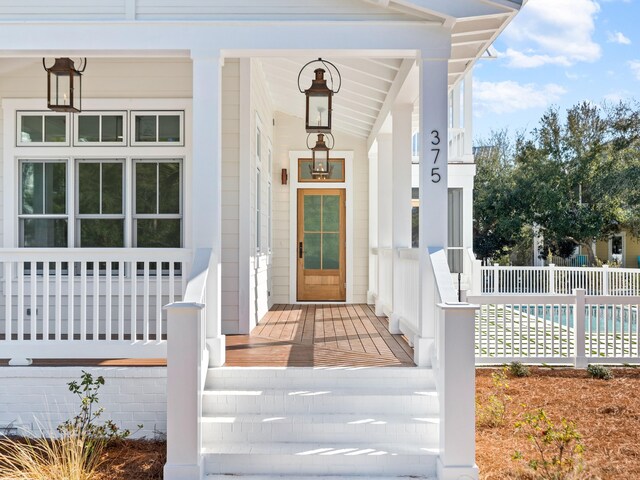 375 Morgans Trl, Santa Rosa Beach, FL 32459 - view of exterior entry with a fenced in pool and a porch