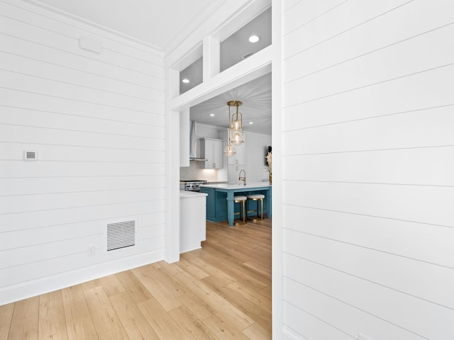 375 Morgans Trl, Santa Rosa Beach, FL 32459 - hallway with a sink, visible vents, crown molding, and light wood finished floors