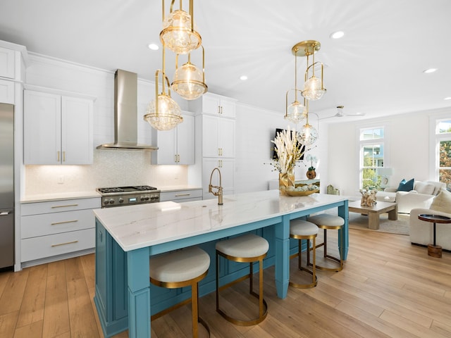 375 Morgans Trl, Santa Rosa Beach, FL 32459 - kitchen featuring light wood finished floors, wall chimney exhaust hood, a sink, stove, and backsplash