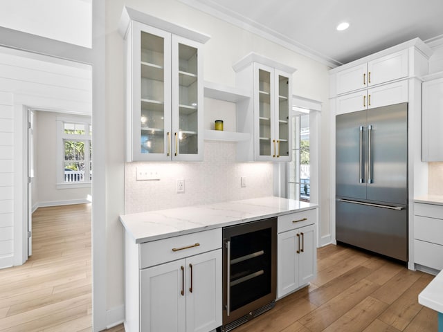 375 Morgans Trl, Santa Rosa Beach, FL 32459 - kitchen featuring built in refrigerator, wine cooler, decorative backsplash, light wood finished floors, and white cabinets
