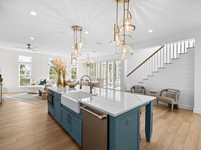 375 Morgans Trl, Santa Rosa Beach, FL 32459 - kitchen with a sink, blue cabinets, stainless steel dishwasher, open floor plan, and light wood-type flooring