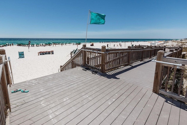 exterior space featuring a deck with water view and a view of the beach