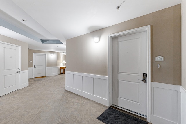 empty room featuring a wainscoted wall and light carpet
