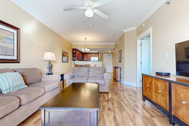 living room featuring crown molding, light wood-style flooring, ceiling fan with notable chandelier, and baseboards