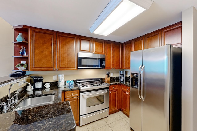 kitchen featuring a sink, light tile patterned floors, dark stone countertops, stainless steel appliances, and open shelves