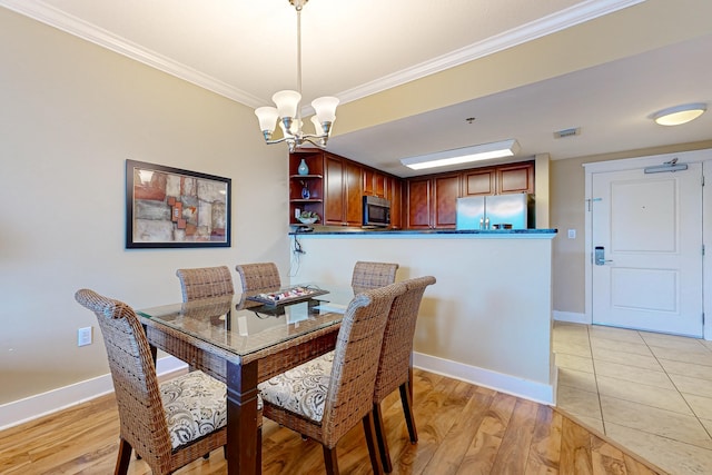 dining area featuring visible vents, baseboards, a chandelier, ornamental molding, and light wood-style flooring