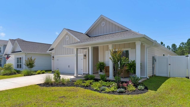 33 Spoonbill Rd, Santa Rosa Beach, FL 32459 - view of front of house with board and batten siding, a front yard, covered porch, a garage, and a gate