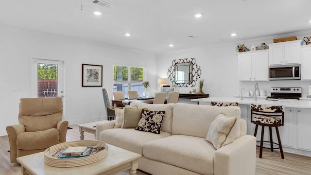 33 Spoonbill Rd, Santa Rosa Beach, FL 32459 - living room featuring crown molding, light wood-style flooring, recessed lighting, and visible vents