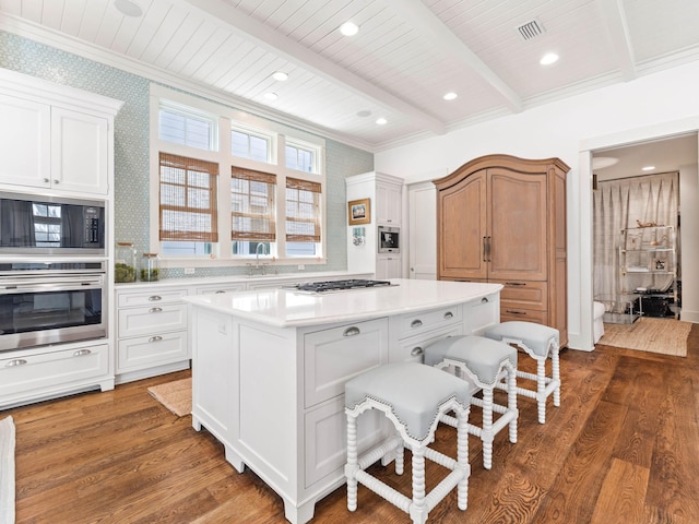 223 Western Lake Dr, Santa Rosa Beach, FL 32459 - kitchen with light countertops, beam ceiling, wood finished floors, appliances with stainless steel finishes, and a center island