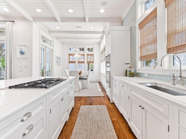 223 Western Lake Dr, Santa Rosa Beach, FL 32459 - kitchen featuring light countertops, stainless steel appliances, dark wood finished floors, a sink, and beamed ceiling