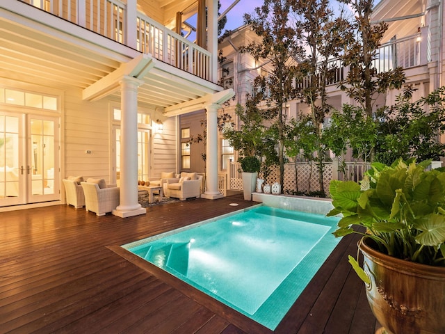 223 Western Lake Dr, Santa Rosa Beach, FL 32459 - pool at dusk featuring outdoor lounge area and french doors