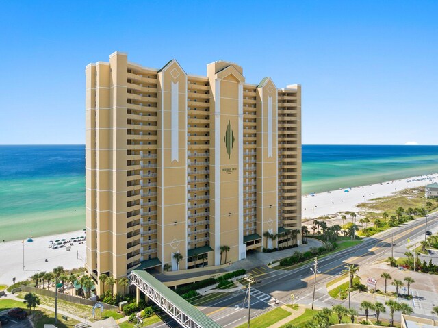 view of building exterior featuring a view of the beach and a water view