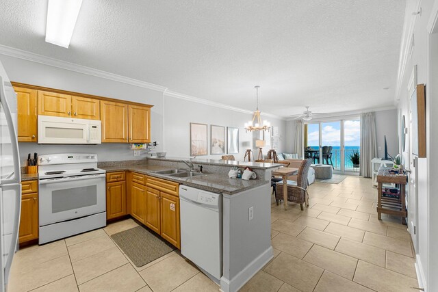 kitchen featuring a sink, white appliances, a peninsula, and crown molding