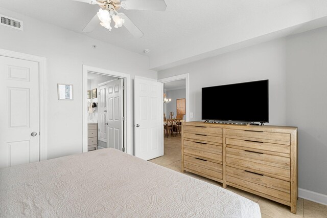 bedroom featuring visible vents, ensuite bath, light tile patterned flooring, baseboards, and ceiling fan