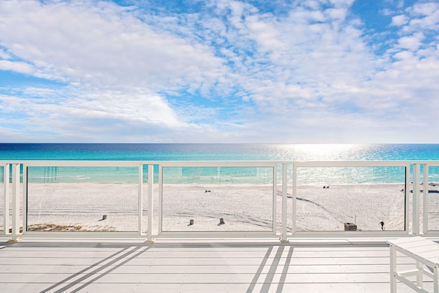 balcony with a water view and a view of the beach