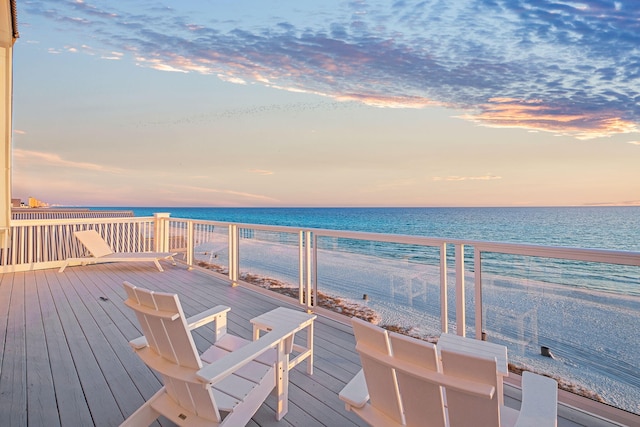 deck featuring a view of the beach and a water view