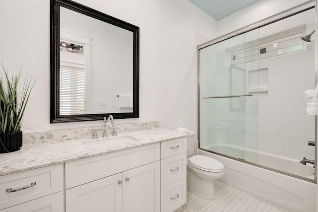 full bath featuring vanity, toilet, and combined bath / shower with glass door