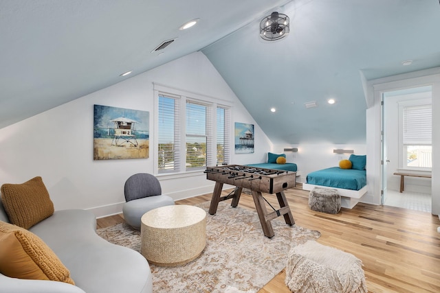 interior space with a wealth of natural light, visible vents, lofted ceiling, and wood finished floors